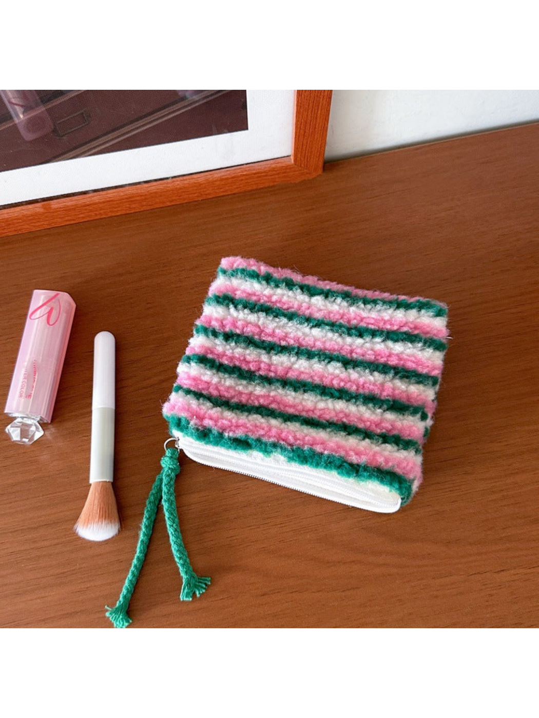 Stripes makeup bag with green, pink and white horizontal stripes and a green cord pull