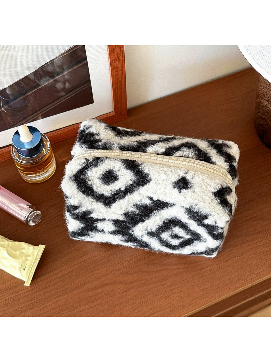 Diamond makeup bag with black and ivory geometric pattern and looped surface texture