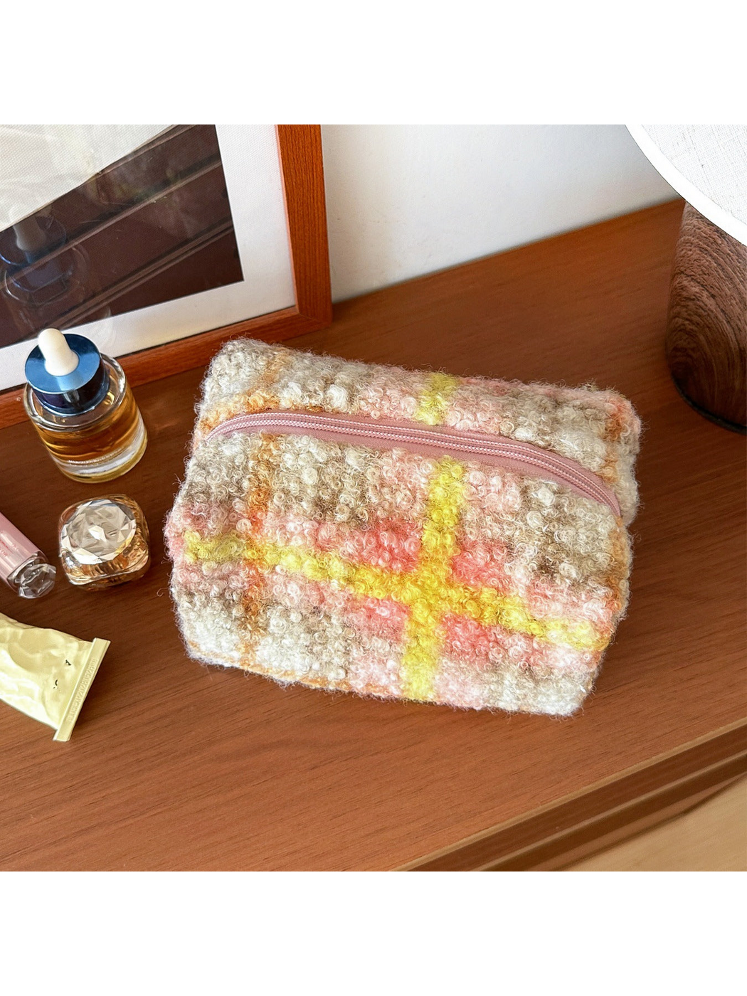 Yellow makeup bag with cream and taupe plaid crossed by yellow, coral pink and orange bands