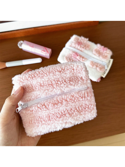 Stripes makeup bag held in one hand, showing raised horizontal texture