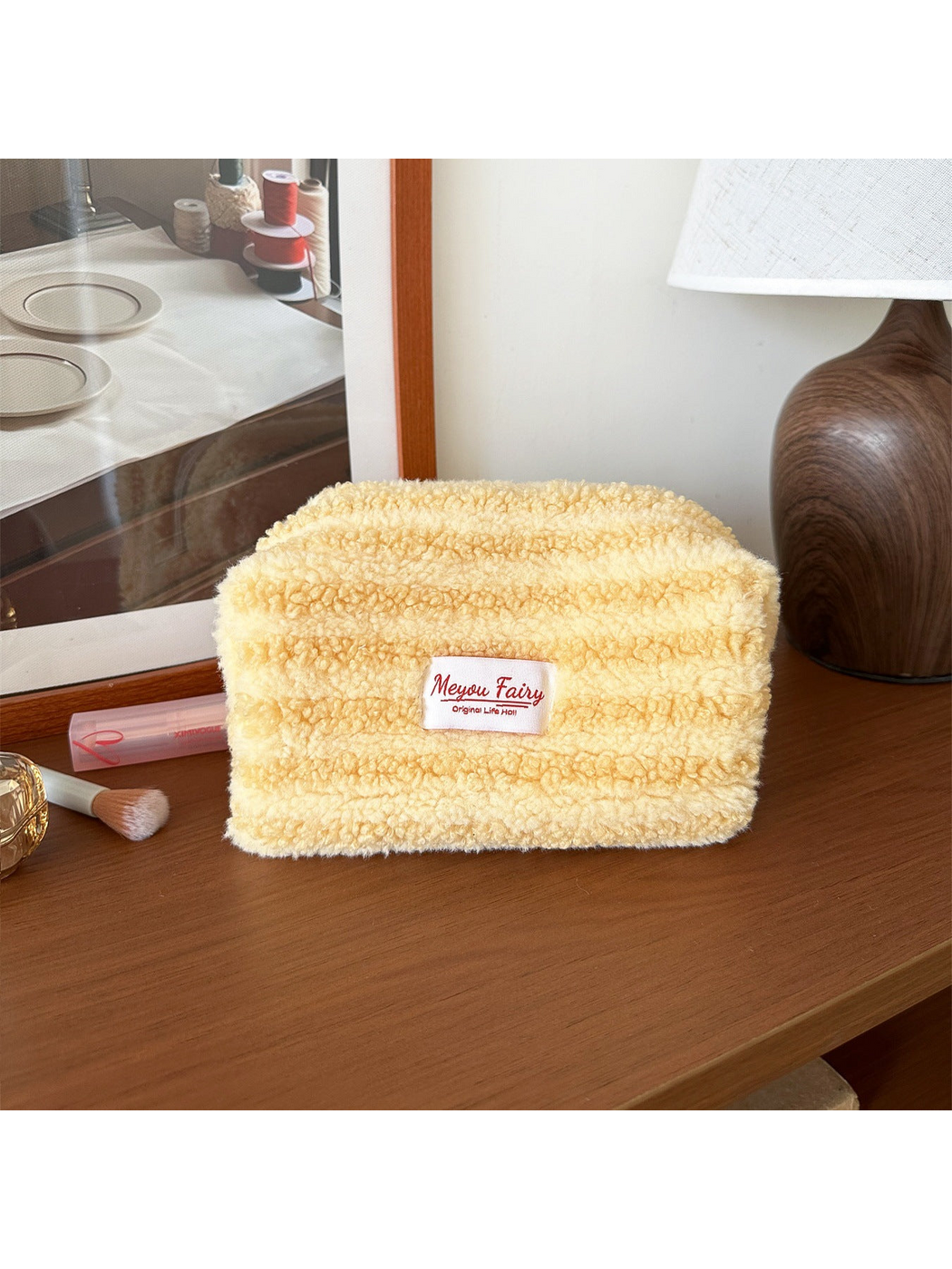 Yellow cosmetic pouch with horizontal texture bands and a front label