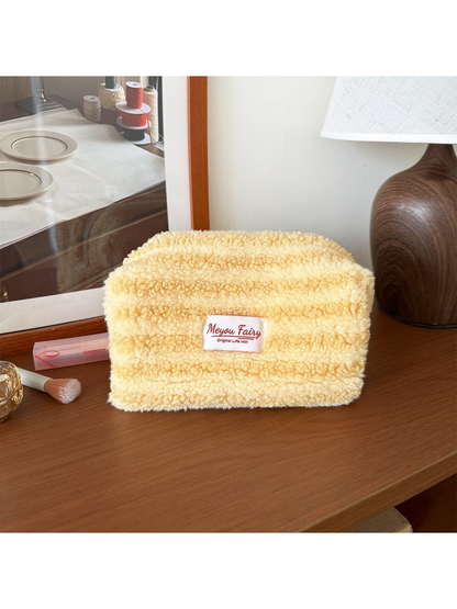 Yellow cosmetic pouch with horizontal texture bands and a front label