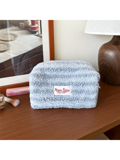 Light Blue cosmetic pouch with horizontal texture bands and a front label