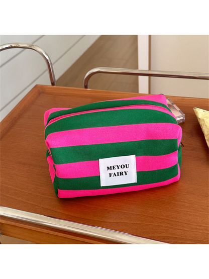 Green striped makeup bag with fuchsia stripes and a white front label