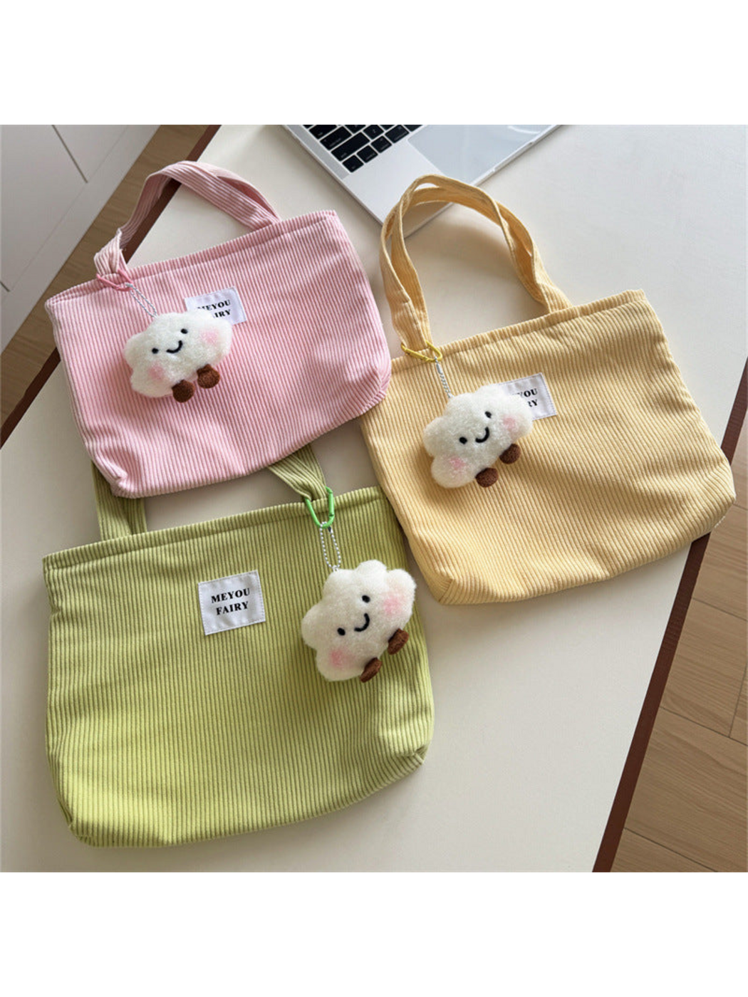 Pink, Yellow and Green ribbed tote bags with smiling cloud charms displayed together