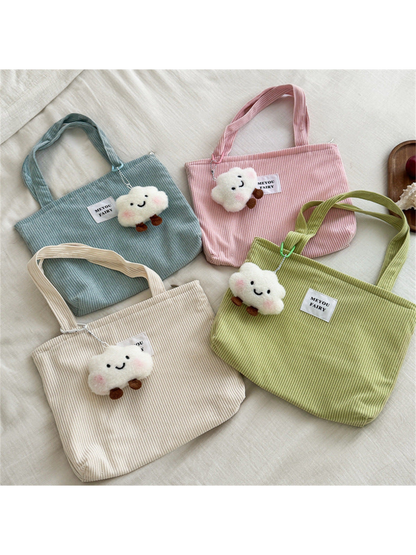 Blue, Pink, Beige and Green tote bags with cloud charms arranged together