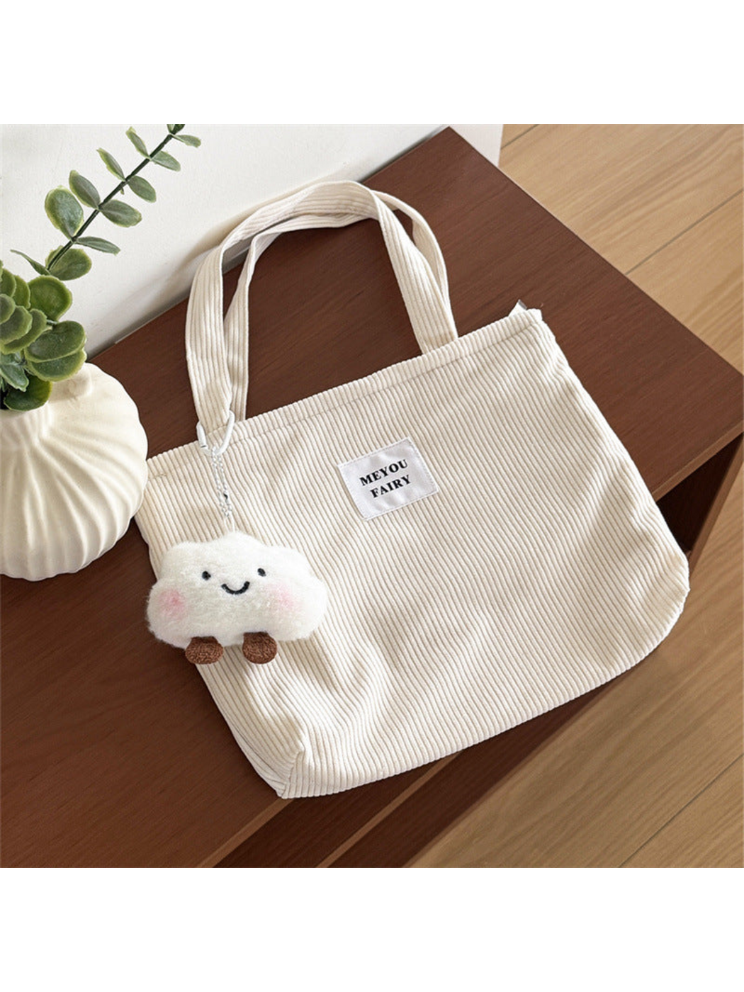 Beige ribbed tote bag with two top handles and smiling cloud charm