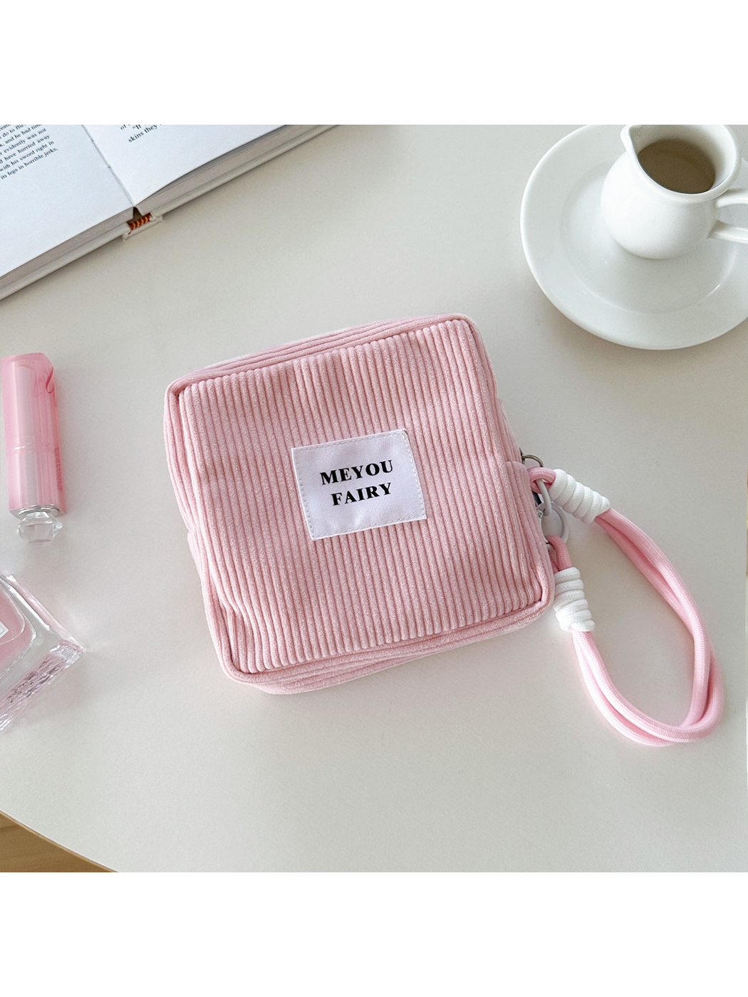 Pink ribbed makeup bag with wrist loop and white front label