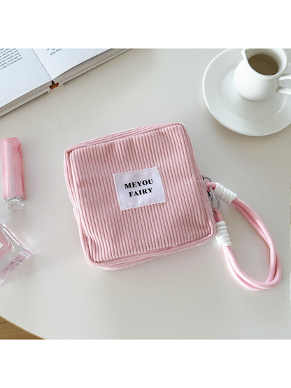 Pink ribbed makeup bag with wrist loop and white front label