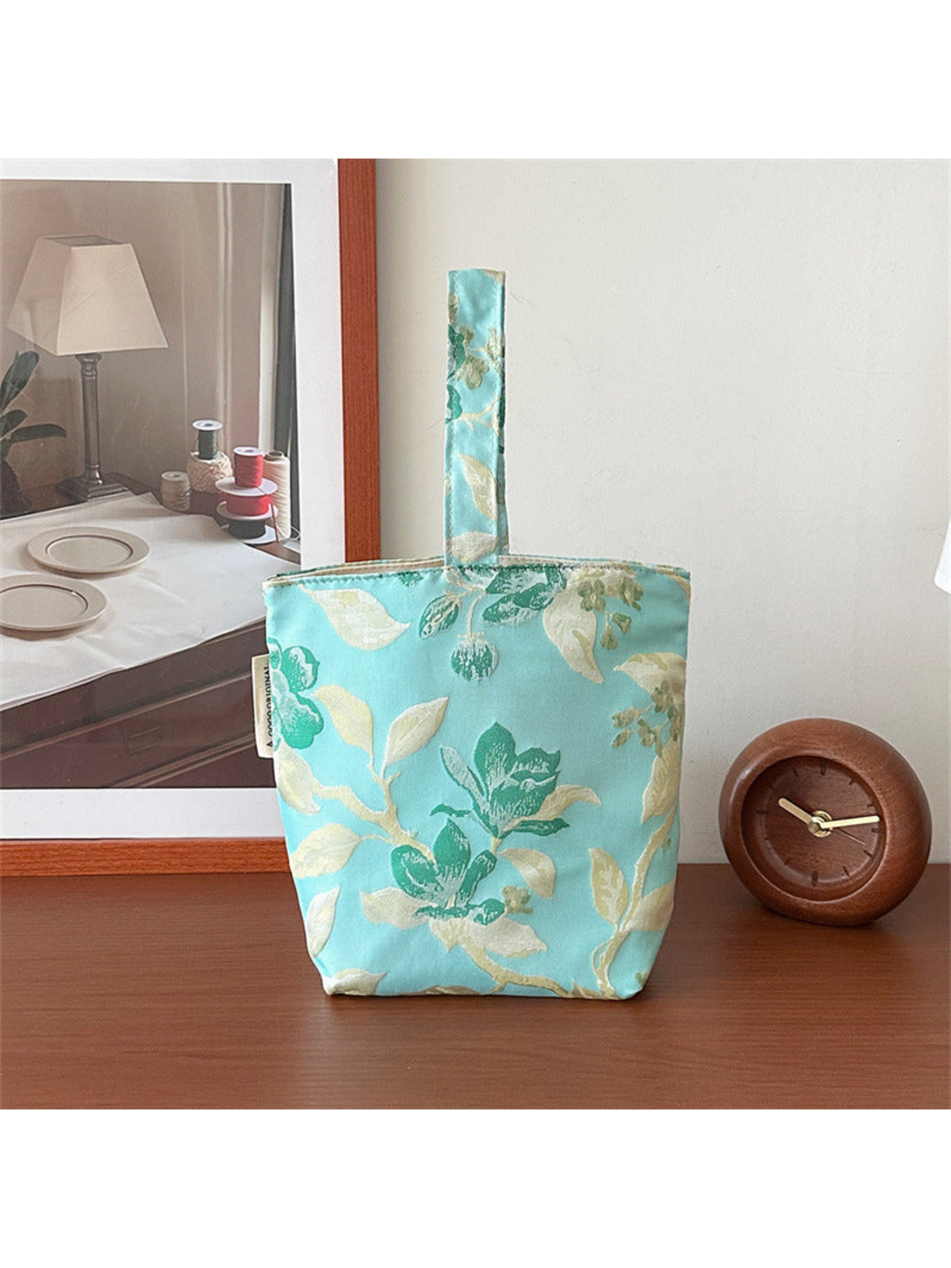 Turquoise floral bucket bag standing upright, showing the opposite patterned face