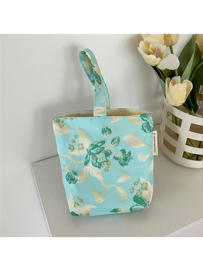 Turquoise floral bucket bag with loop handle and visible pale opening