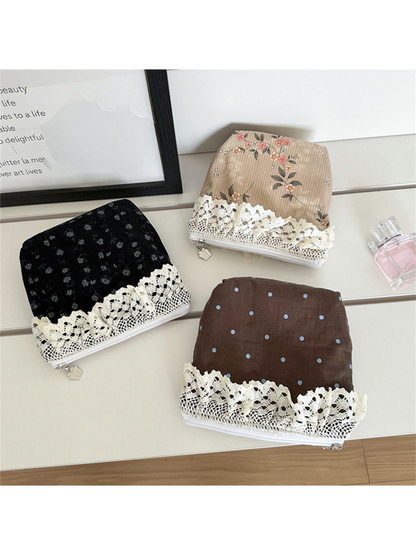 Black, Brown and Beige patterned pouches displayed together with ivory lace trim