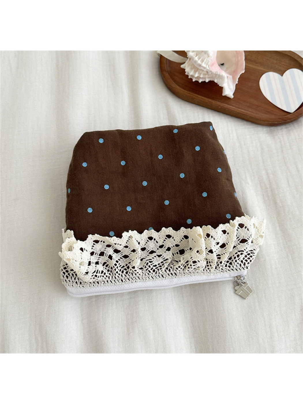 Brown pouch with light-blue polka dots and ivory lace trim, flat view