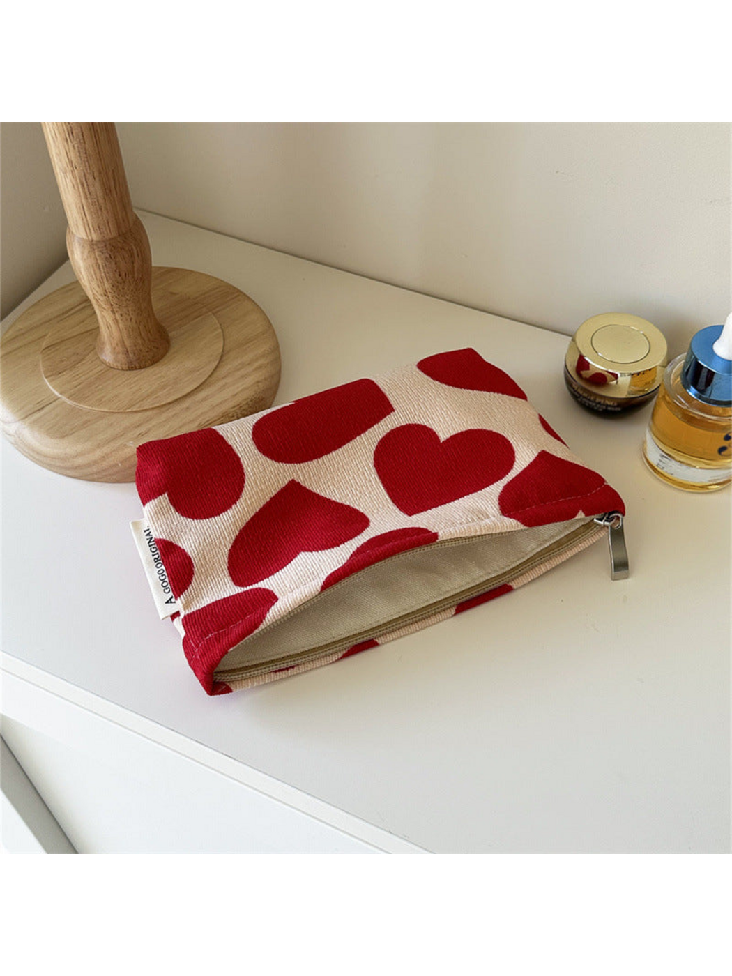 Small cream pouch with red hearts, shown open with its interior visible