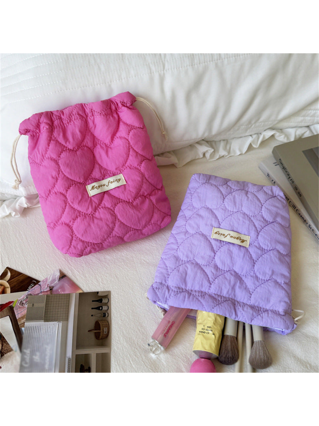 Fuchsia and Purple heart-quilted pouches with brushes beside the Purple opening