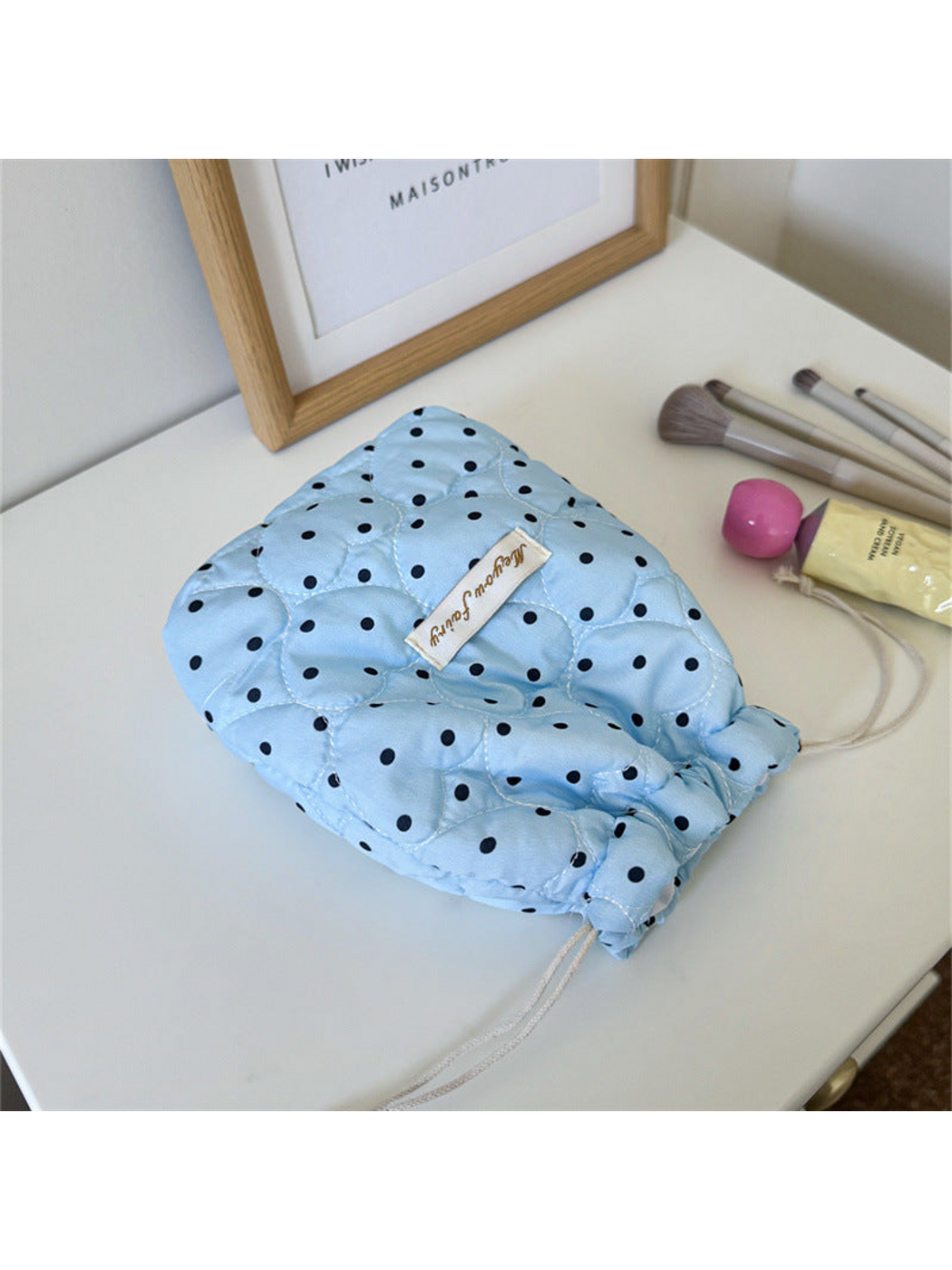 Blue cosmetic pouch with black polka dots, heart-shaped quilting and pale drawstrings