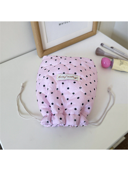 Pink cosmetic pouch with black polka dots, heart-shaped quilting and gathered opening