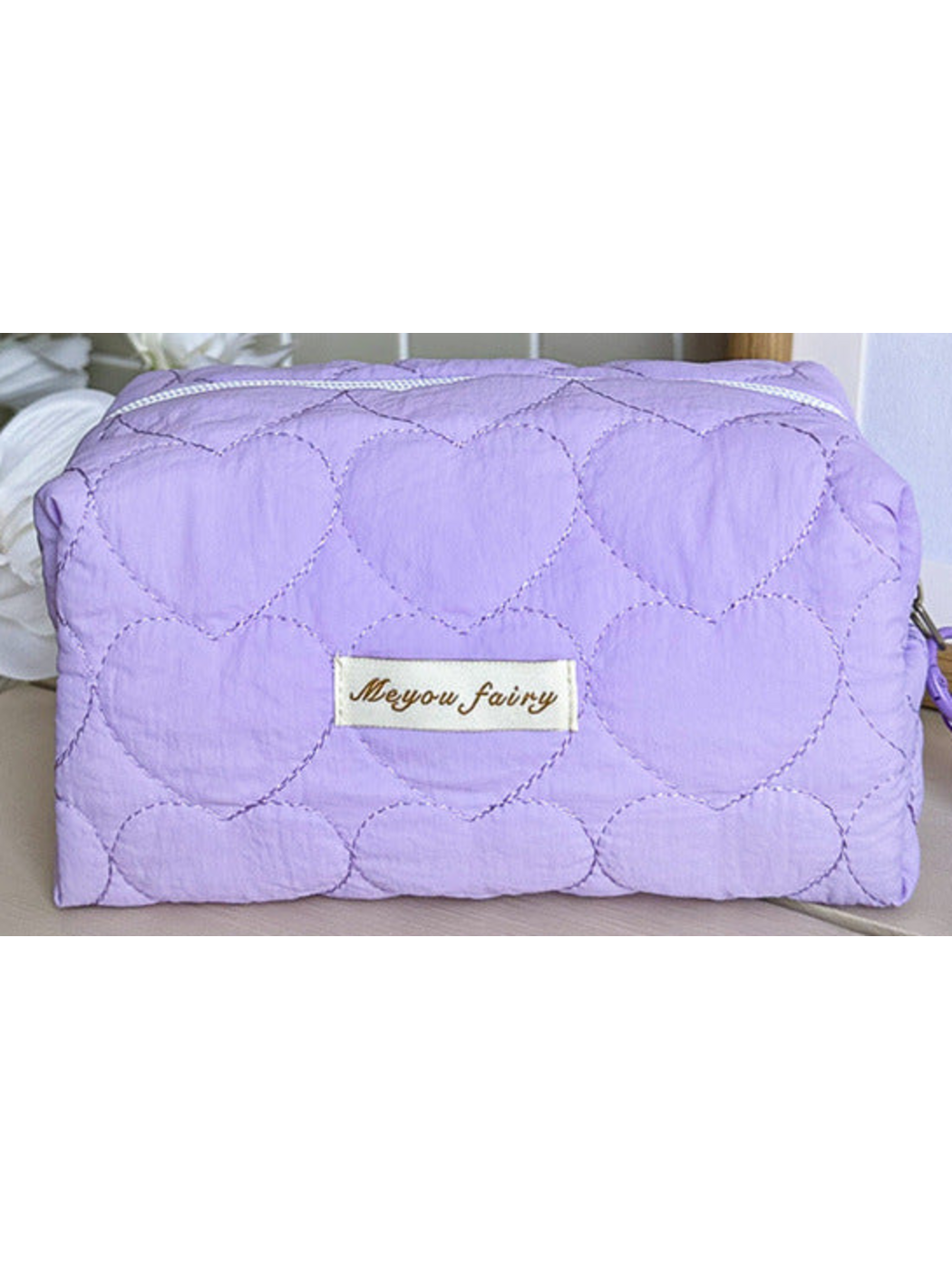 Purple heart-quilted pouch body with white zipper and sewn label; limited detail view