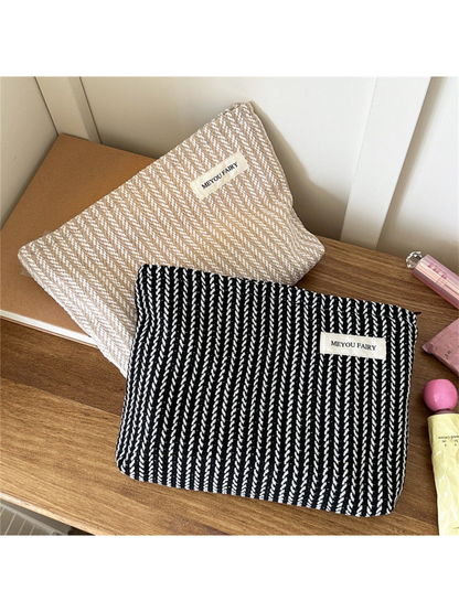 Black and Beige makeup pouches with contrasting textured stripes displayed together
