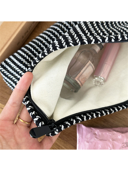 Close-up of the Black makeup pouch showing pale lining and the opening edge