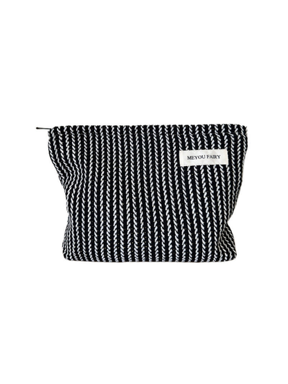 Black makeup pouch with contrasting white textured stripes, front view