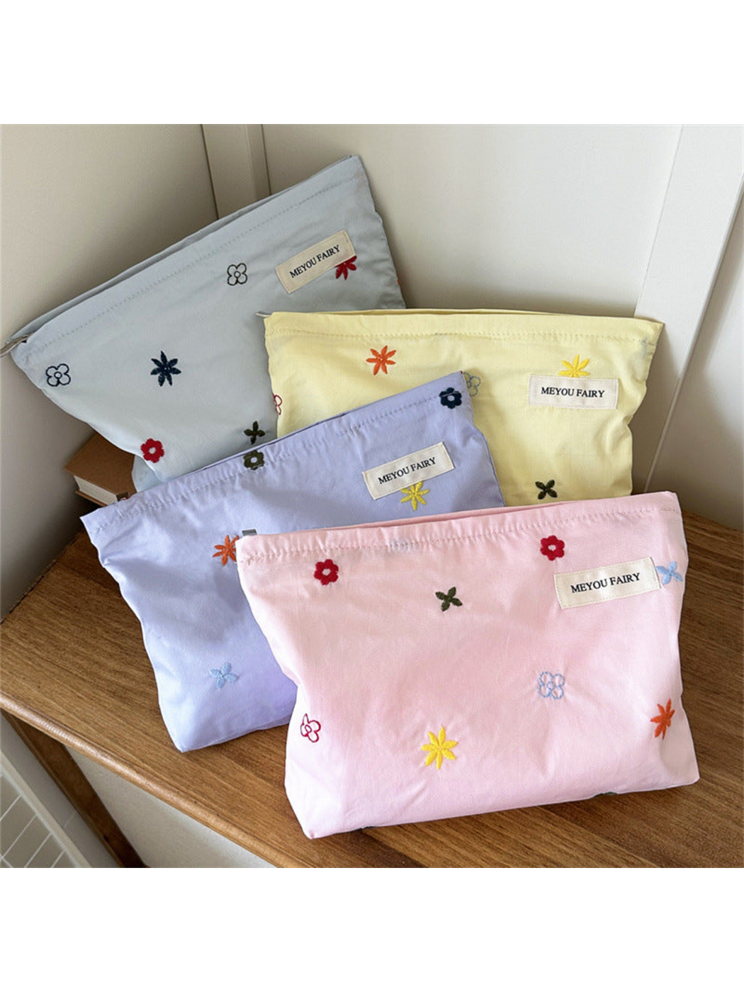 Pink, Blue, Yellow and Purple makeup bags with multicolored floral embroidery displayed together