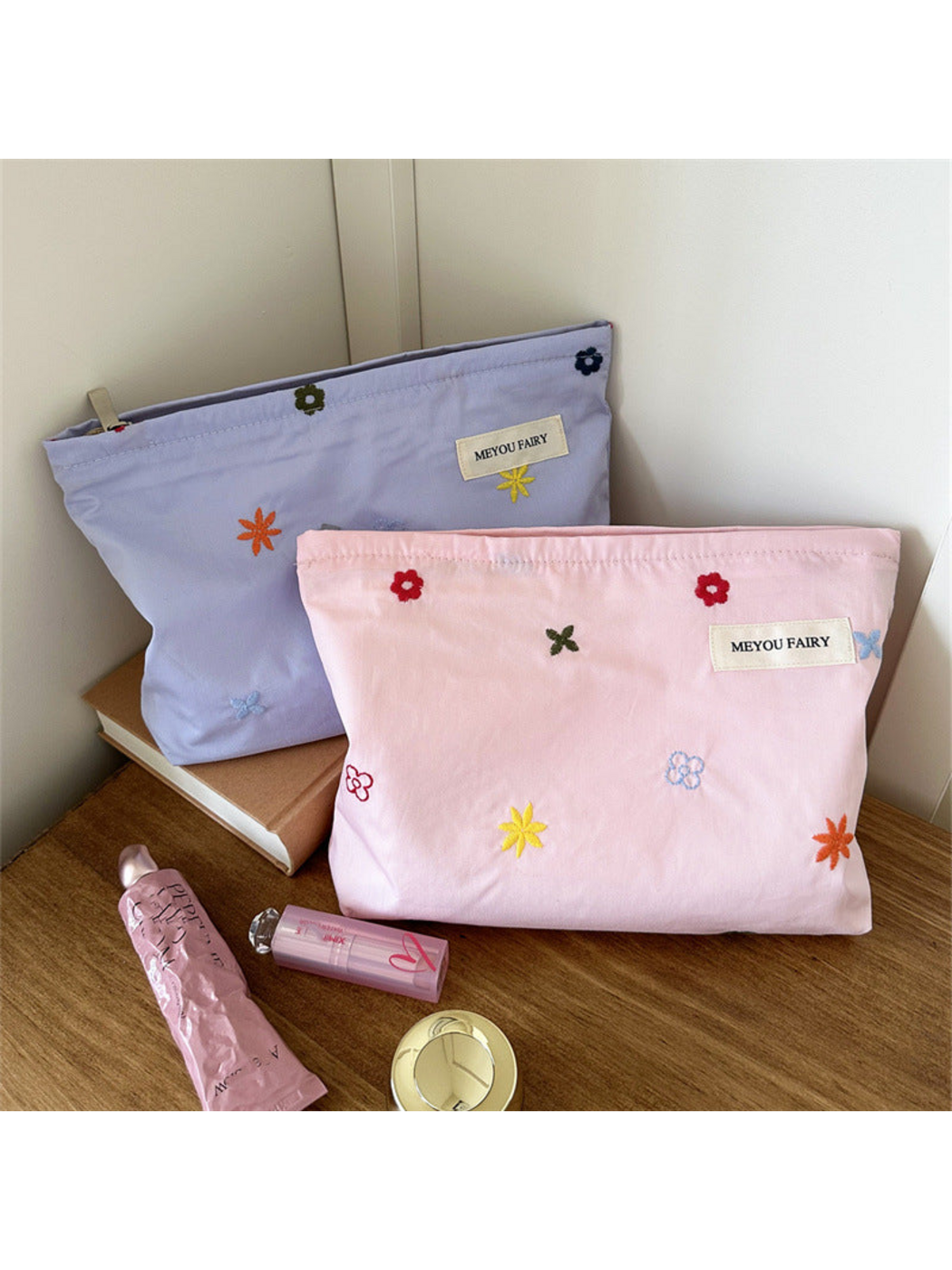 Pink and Purple floral makeup bags standing beside cosmetic props