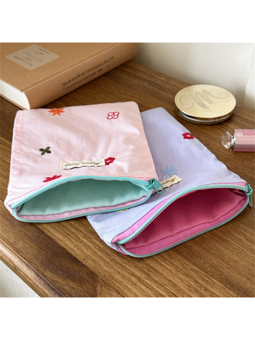 Open Pink and Purple floral embroidered pouches showing mint and pink interiors