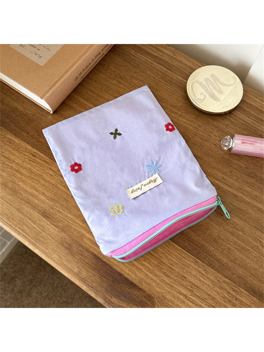 Purple floral embroidered pouch with a partially open edge