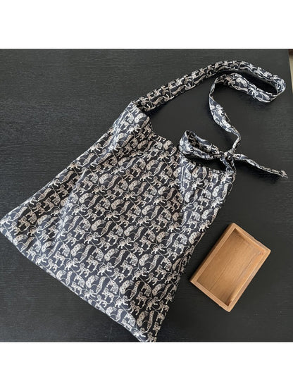 Side view of Cosbai black cat packable tote showing bag depth and handles