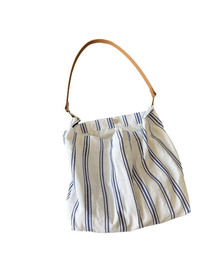 Side view of Cosbai blue stripe slouch shoulder bag highlighting its slouchy shape and blue stripes