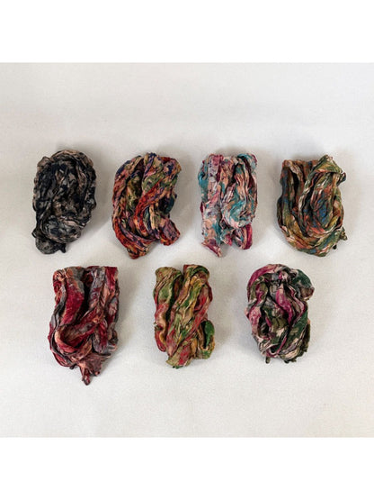 Scarvii scarf displayed on a wooden surface emphasizing the artistic textured print