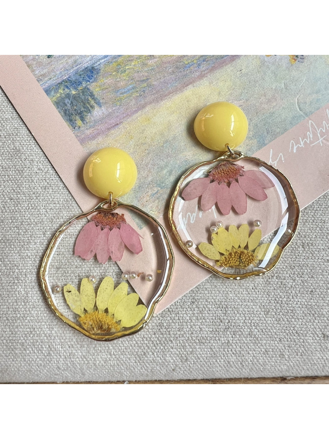 Model wearing clear floral statement earrings with light reflecting on petals