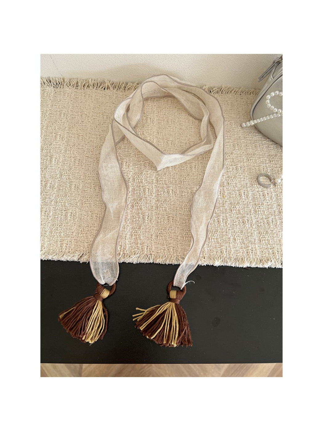 Scarvii skinny scarf draped over a chair showing full length and tassels