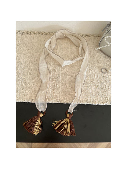 Scarvii skinny scarf draped over a chair showing full length and tassels