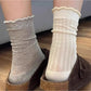 Pair of Rufia soft ribbed crew socks with ruffle trim in light beige