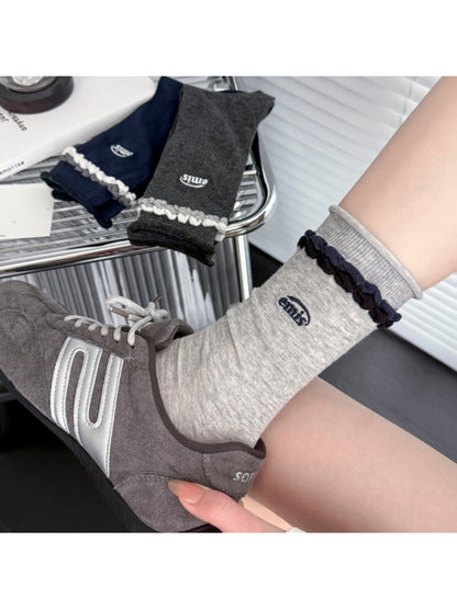 Rufia contrast braid knit socks worn with rolled-up jeans and brown shoes