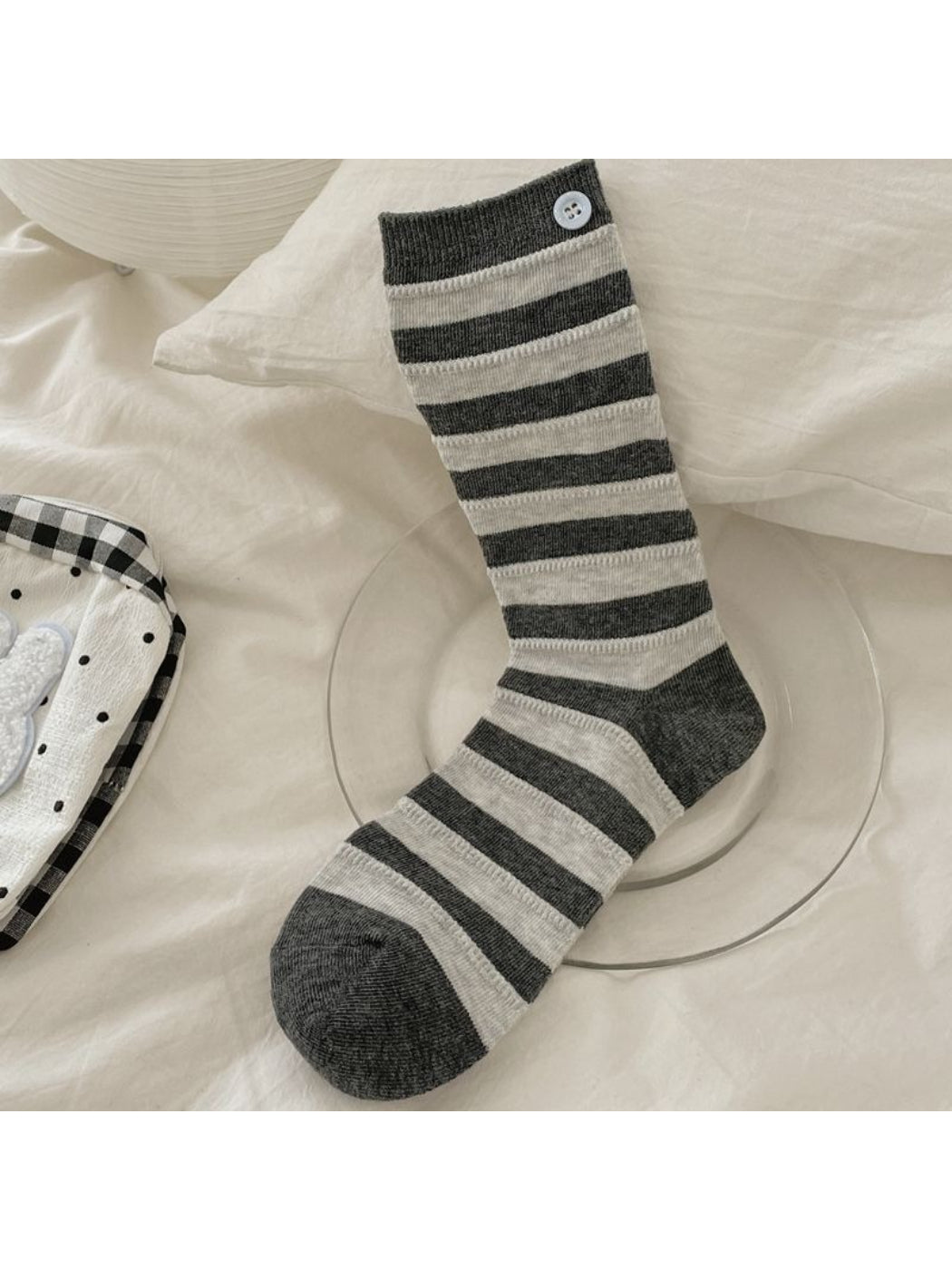 Rufia striped crew socks rolled up to showcase button design and fabric texture