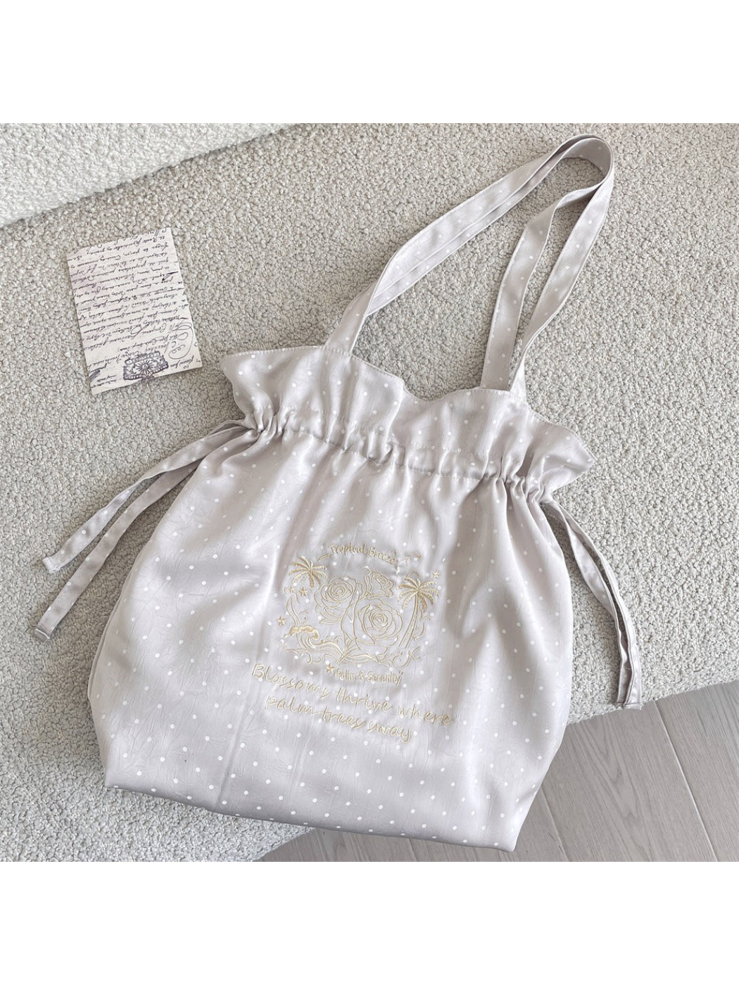 Cosbai drawstring shoulder bag hanging on a hook displaying full design