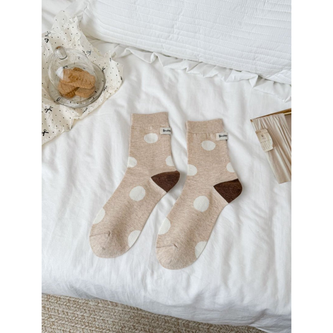 Rufia socks displayed on a wooden surface showing contrast heel and dot design