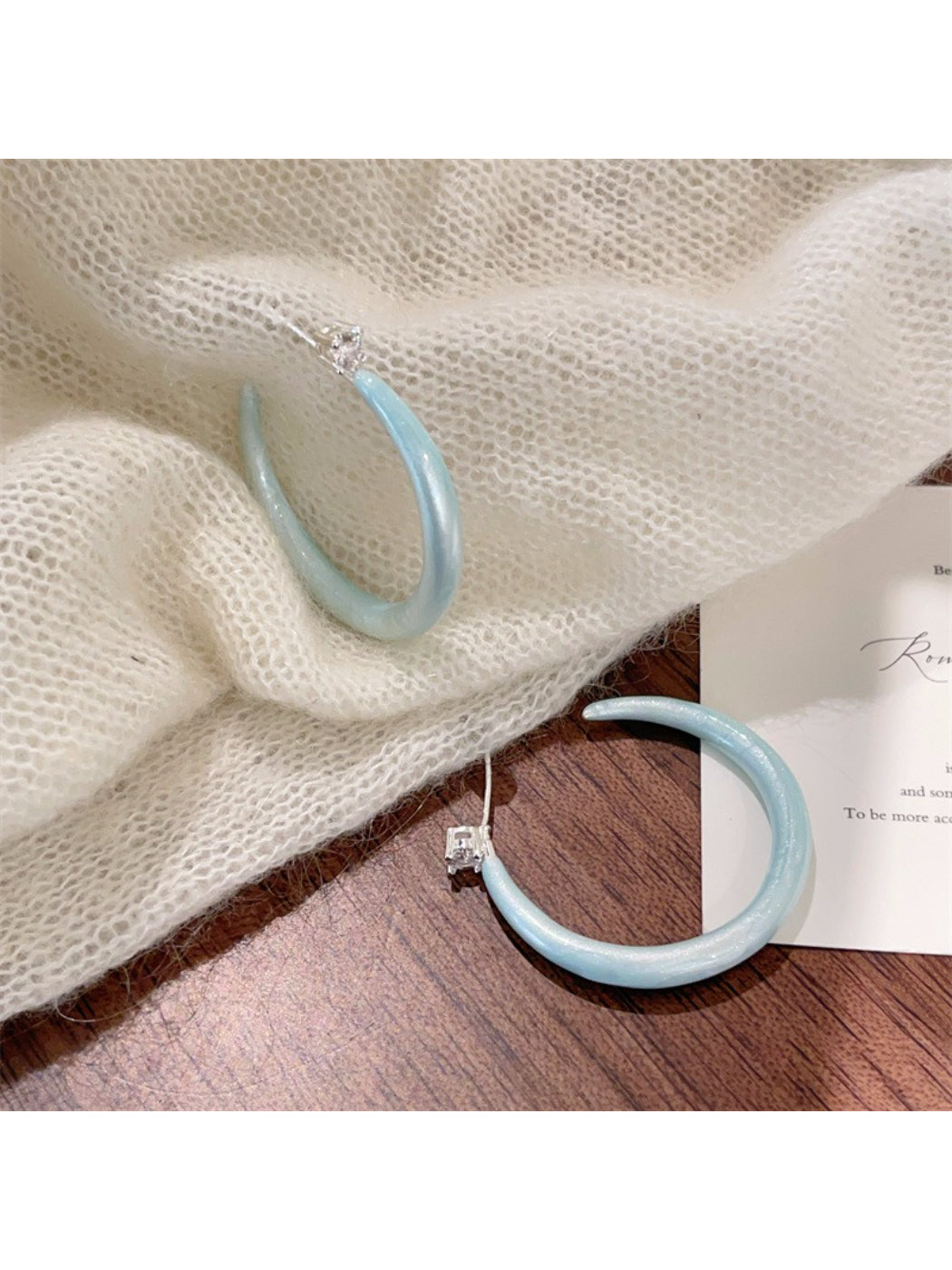 Glossy color hoop earrings packaged in a branded box