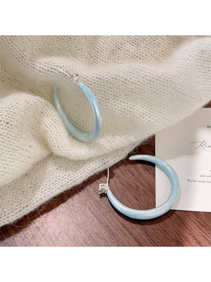 Glossy color hoop earrings packaged in a branded box