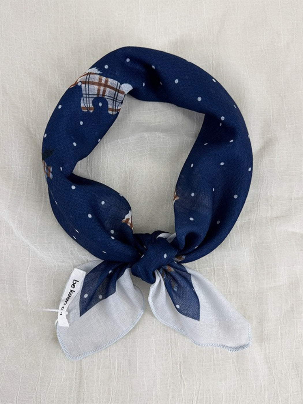 Close-up of Scarvii Sheer Pony Dot Square Scarf fabric texture with small black dots on white
