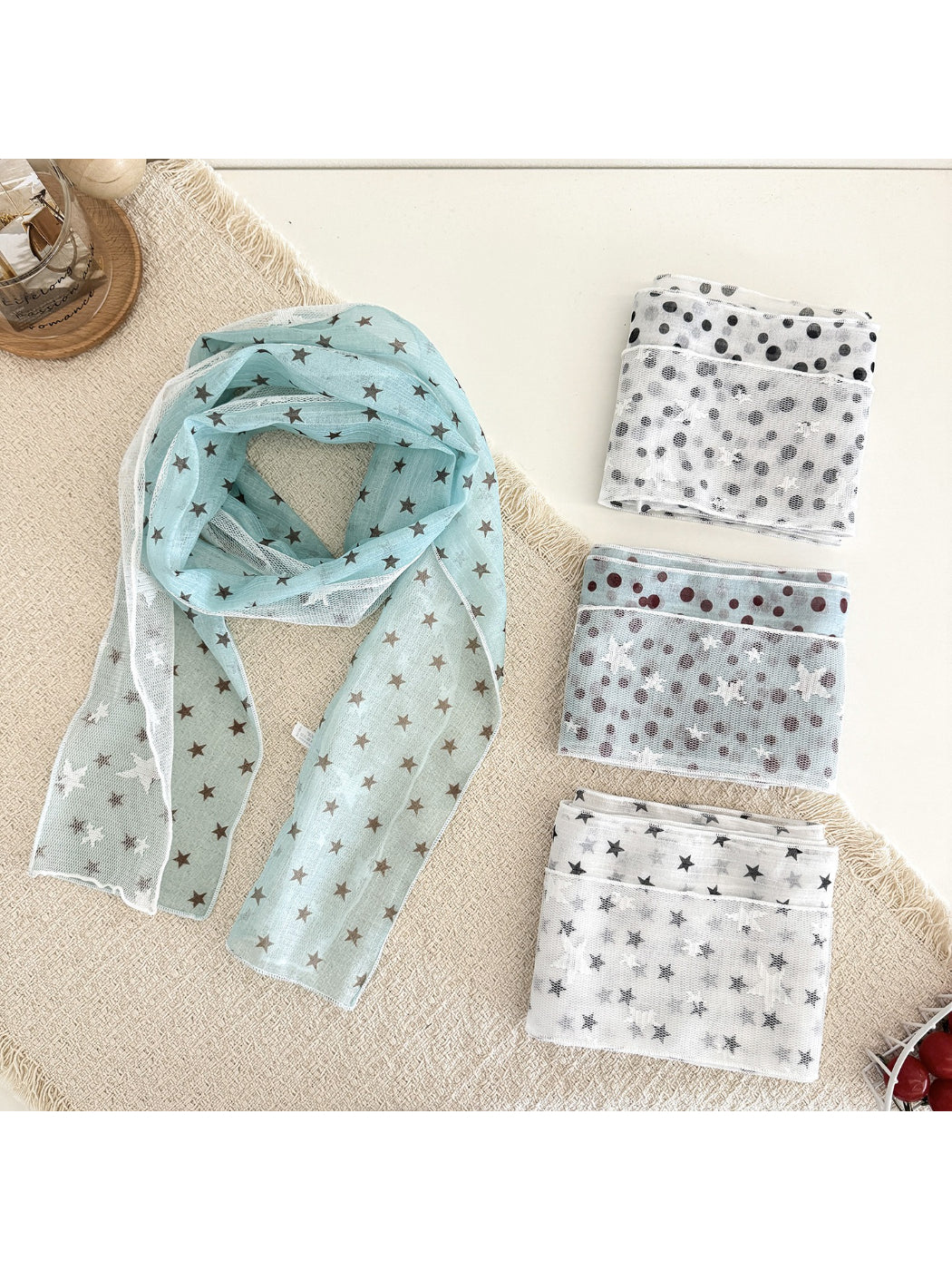 Scarvii sheer scarf with white star print on black fabric displayed flat