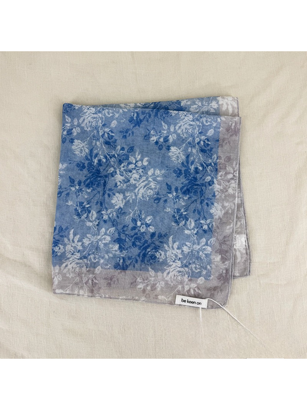 Scarvii scarf laid flat displaying full square shape and floral border print