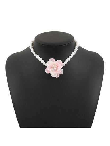 Model wearing white beaded flower necklace paired with a light-colored top