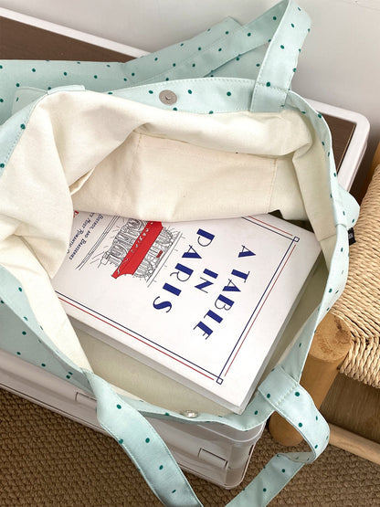 Cosbai Dot Print Graphic Tote Bag placed on a wooden surface with lighting