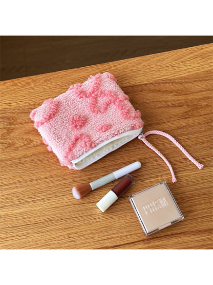 Red heart-shaped plush pouch held in hand to show size and softness