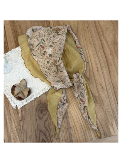 Lightweight scarf folded to display botanical design and fabric texture