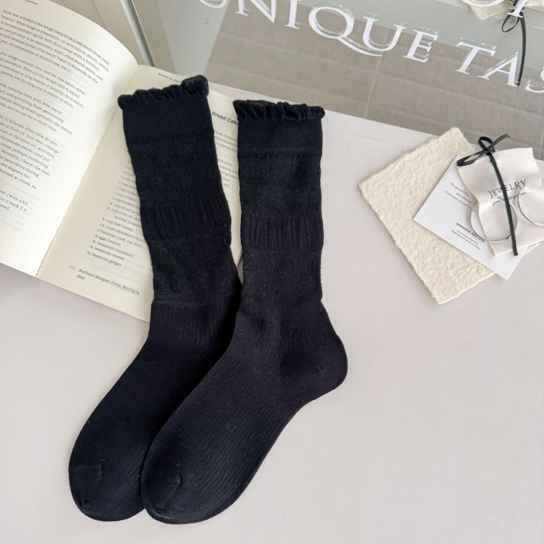 Pair of Rufia socks folded to display floral trim and ribbed knit texture in soft white color